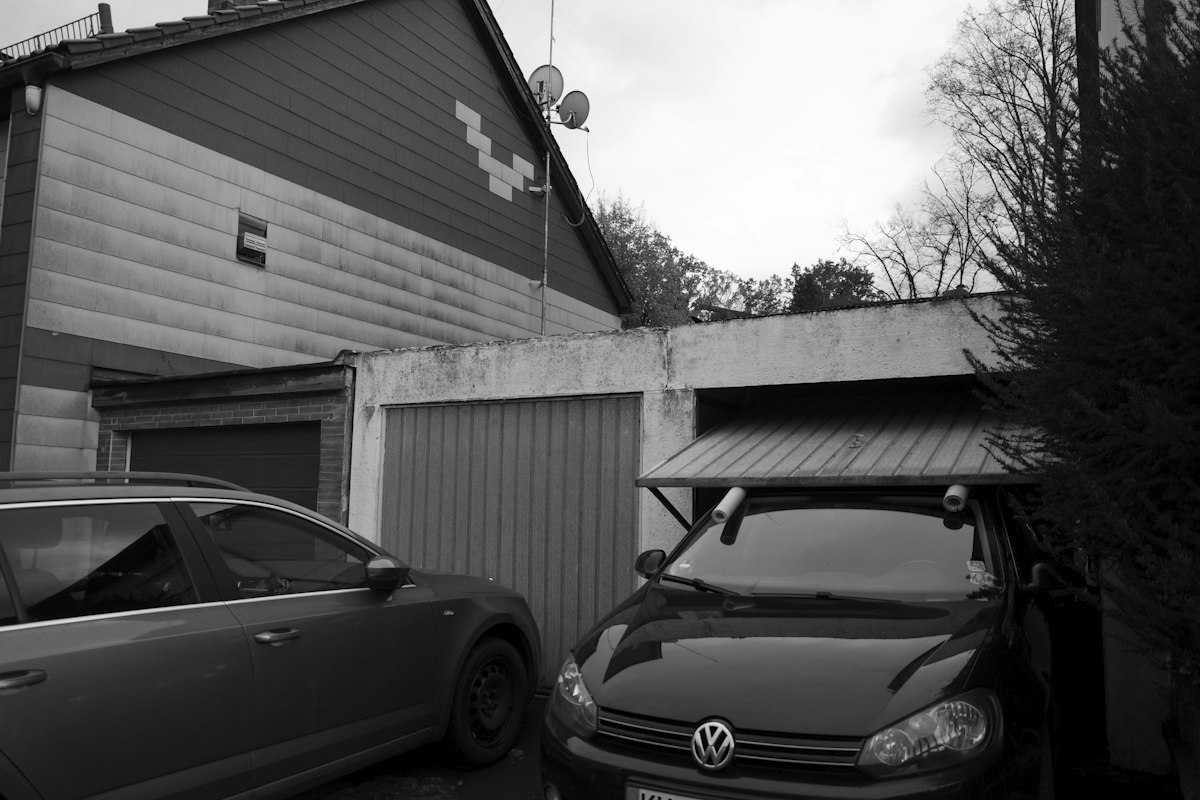 Cars parked on a driveway in front of a closed garage door